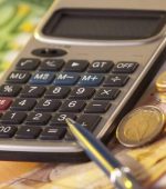 "European money on a table with calculator and coins, money and banking concept"