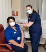 Staff member Rosemarie McLaughlin getting her vaccine from staff member Joanne Craig