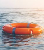 Orange lifebuoy in sea on water. Life ring floating on top of water. Life ring in ocean.Toning.