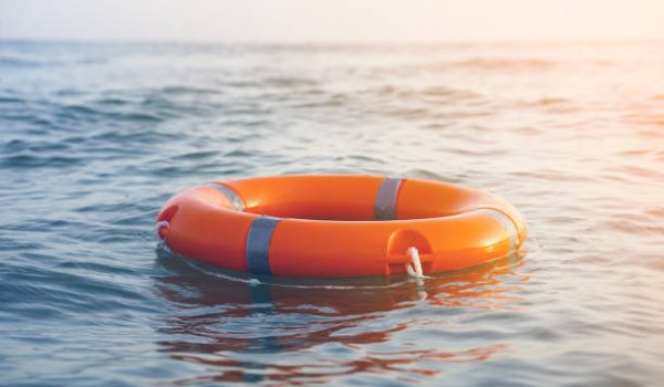 Orange lifebuoy in sea on water. Life ring floating on top of water. Life ring in ocean.Toning.