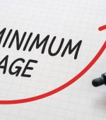 White paper written "MINIMUM WAGE" with markers.