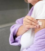 Woman using transdermal patch  in the bathroom at home .