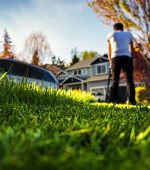 Young man mowing the lawn.