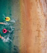 Aerial view of friends relaxing and having fun in the water