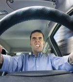 A furious man driving, as seen from behind the wheel. Shot using a very wide fisheye lens.
