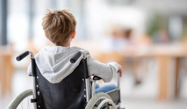 young-boy-in-wheelchair-wearing-gray-hoodie-gazing-thoughtfully-in-a-bright-modern-space-symbolizing-resilience-and-determination-in-life-photo